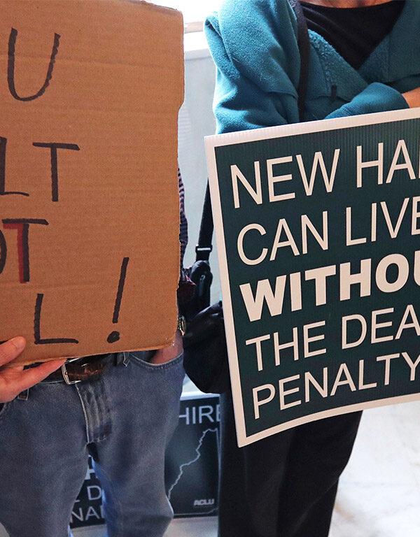 Demonstrators carrying signs advocating the abolition of the death penalty in New Hampshire