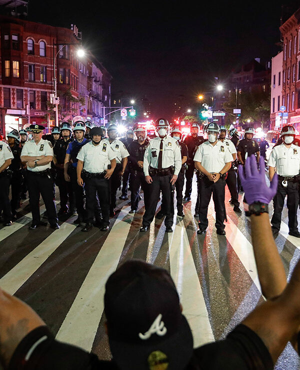 Protesters take a knee on Flatbush Avenue in front of New York City police officers during a solidarity rally for George Floyd