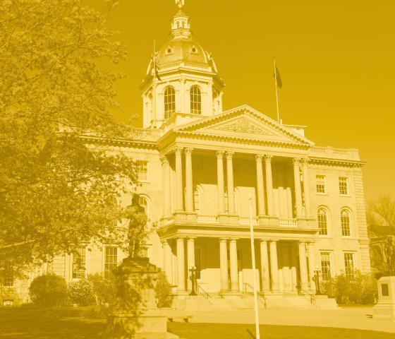 A photo in yellow in gold of the New Hampshire State House.